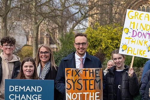 Adam with neurodivergent placards