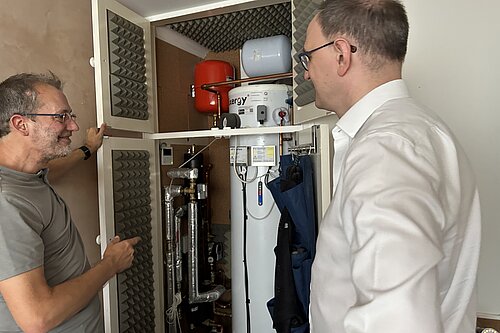 Paul Kershaw showing Ian Sollom MP his heat pump that powers his eco-friendly home