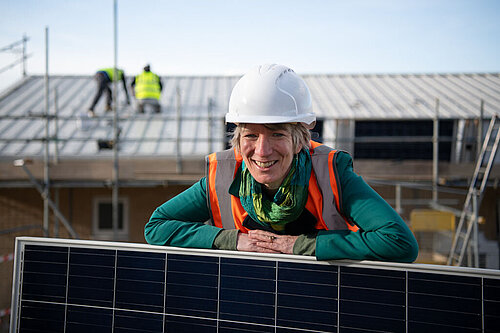 Pippa at a construction site, with solar panels being installed.